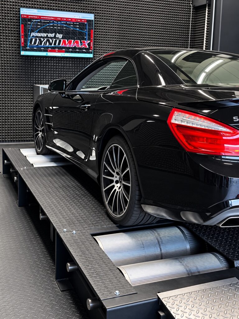 Rear quarter view of a Mercedes-Benz on the Dynomax 4000 BRD rollers, with a power and torque graph on the monitor